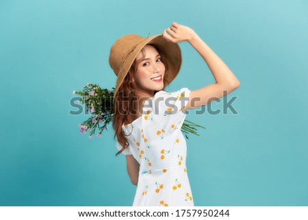 Cute young woman in summer short dress with purple flowers in her hands
