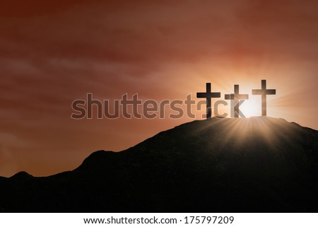 Three cross signs standing on the hill under  orange sky