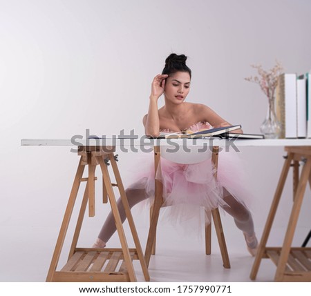 Young beautiful lay wearing pink ballet suit,raise hand touch her face,model posing,blurry light around