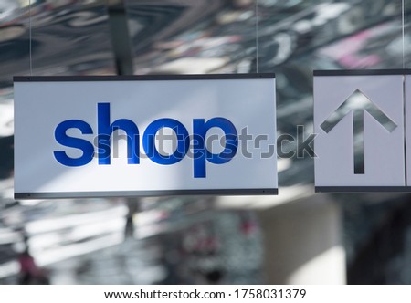shop sign on a window, white sign with blue letters