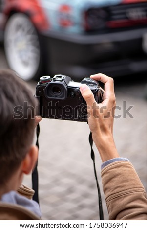 professional photographer takes pictures of a car on the street