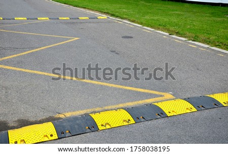 Plastic black sills on an asphalt road are intended to alert drivers and slow down vehicles to yellow black markings