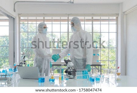 Asian Scientist working on blue test tube to analysis and develop vaccine of covid-19 virus in lab or laboratory in technology medical, chemistry, healthcare, research concept. Experimental science