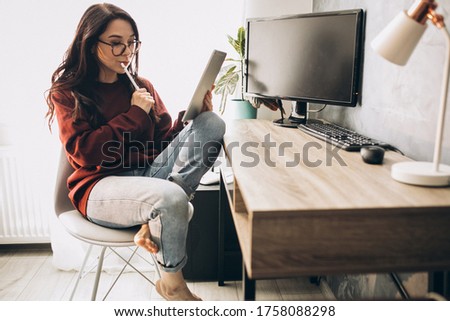 Young woman illustrator working on tablet from home