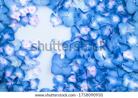 Silhouette of a cross of blue hydrangea flowers. Concept of the Easter holiday, rebirth and faith. religious spiritual banner. 