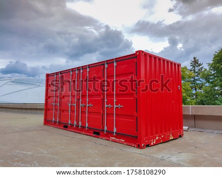 Red container with a dramatic sky in background