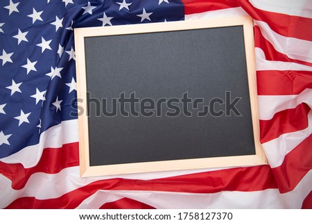 Fabric USA flag and black board or chalkboard on top with space for text, top view 