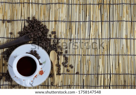 Black coffee cup with wood spoon on bamboo background. Copy space.top view.flat lay.top-down