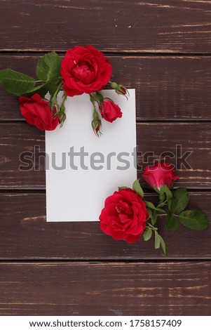 Festive flower composition with greeting card on the brown wooden background. Overhead view