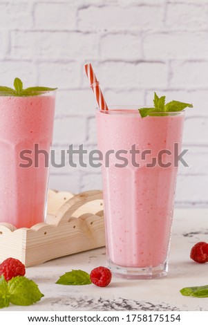 Raspberry milkshake with mint and drinking straws.