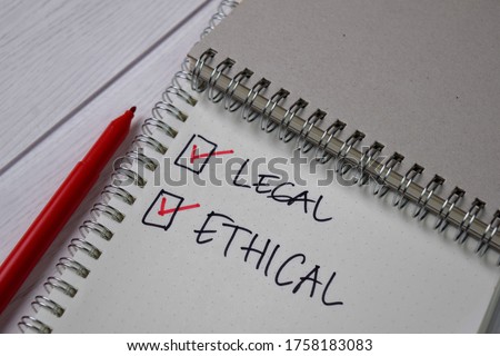 Legal and Ethical write on a sticky note. Supported by an additional services isolated wooden table.