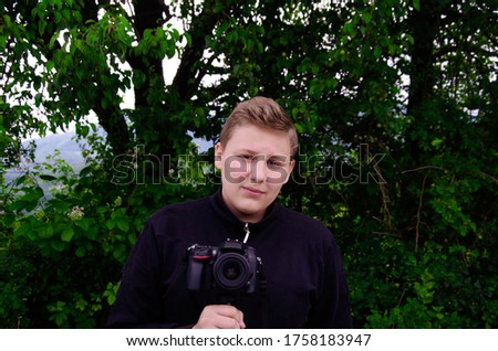 Young caucasian boy taking a shoot with his DSLR camera.