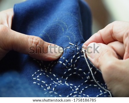 Woman hands sewing stitch blue fabric. Traditional Japanese sewing pattern call "SASHIKO". Traditional Japanese embroidery, learning ,teaching ,how to do,hand work, Japan craft,hobby concept. Royalty-Free Stock Photo #1758186785