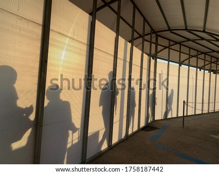 Awesome picture of tourist walking through a passageway in sunshine At Santorini AirPort 


