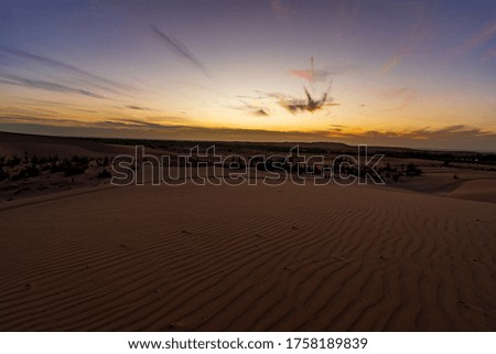 Sunrise on top of Sand Dune with Blue Sky in the background