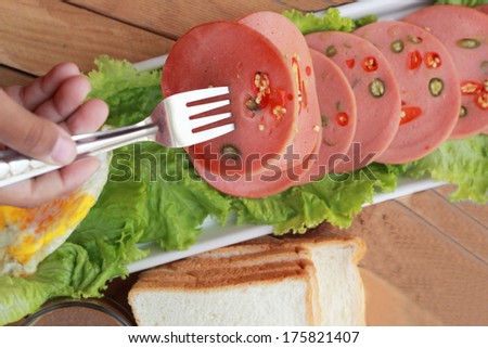 Ham cut into circular discs with red peppers and hot coffee