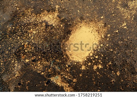 Macro black and gold abstract bubble texture background. Acrylic color in water and oil. 