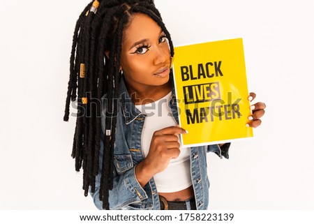 Demonstrator fashionable black woman hold banner with the motto of the black civil rights movement Black Lives Matter to show their solidarity with African Americans in the USA.