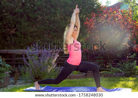 Healthy lifestyle concept. Young woman does a work-out during sunset. Greenery and grass help to improve breathing.