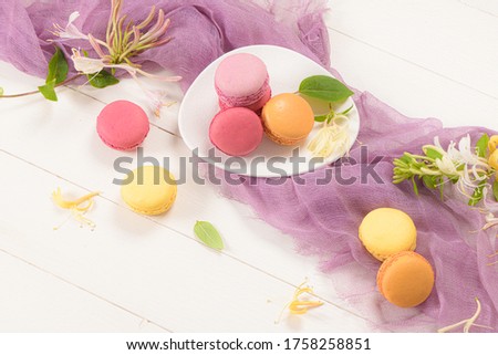 A french sweet delicacy, macaroons variety closeup. Color fresh macarroons on wooden bacground