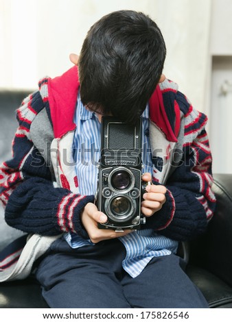 little boy shooting with a vintage camera