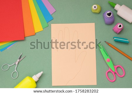 Step by step instructions. Hands with a rainbow heart. Step 5 Circle your hand on folded paper.
