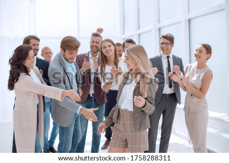 team of young people congratulating their colleague