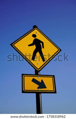 Yellow Pedestrian crosswalk sign with blue sky background. Street safety.            