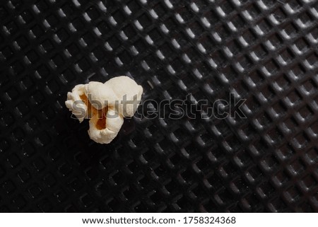 popcorn grains popped in top view, and closeup and black textured background