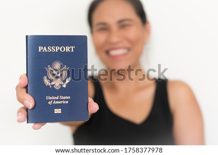 Happy woman holding a us passport. American citizenship. Royalty-Free Stock Photo #1758377978