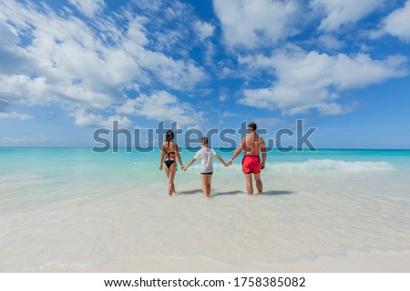 Family having fun and enjoying the white sandy beach on sunny day. Summer vacation for family in tropical paradise caribbean island coast, touristic destination for family vacations and leisure