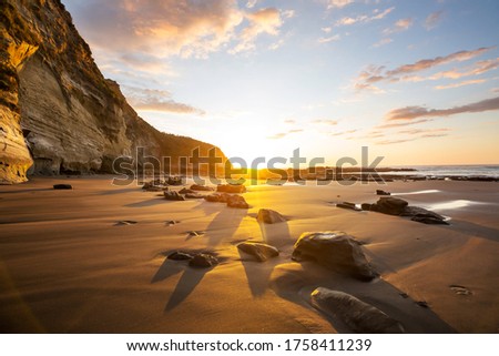 Beautiful Sunset at the Ocean Beach, New Zealand. Inspiring natural and travel background Royalty-Free Stock Photo #1758411239