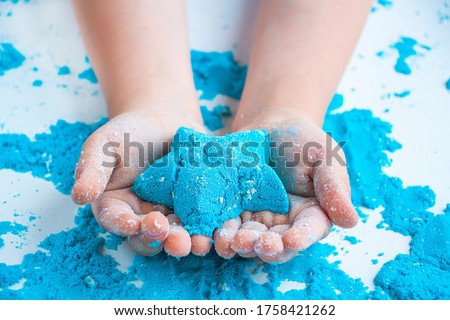 Kids creativity. Kinetic sand games for child development at home. Sand therapy. Children's hands making moldes.Selective focus, chrominance artificial noise, compression artifacts Royalty-Free Stock Photo #1758421262