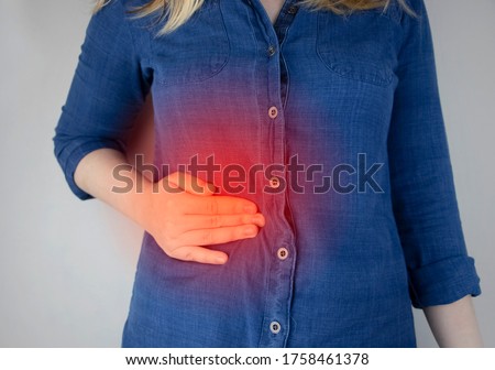 A woman grabs his right side under the ribs. Pain in the liver. Pain syndrome in liver disease. Hepatologist examination Royalty-Free Stock Photo #1758461378