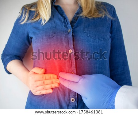 A woman grabs his right side under the ribs. Pain in the liver. Pain syndrome in liver disease. Hepatologist examination Royalty-Free Stock Photo #1758461381