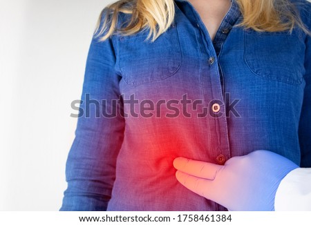A woman grabs his right side under the ribs. Pain in the liver. Pain syndrome in liver disease. Hepatologist examination Royalty-Free Stock Photo #1758461384