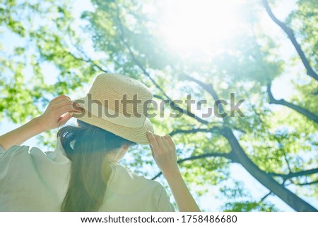 Hand of young woman with hat in the verdure Royalty-Free Stock Photo #1758486680