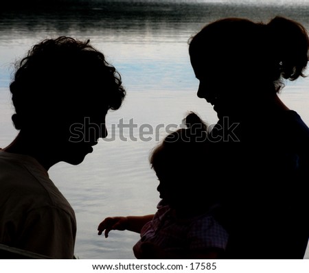 young family in silhouette at a lake