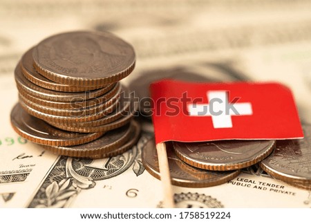 Stack of coins with Switzerland flag on USA America dollar banknotes.