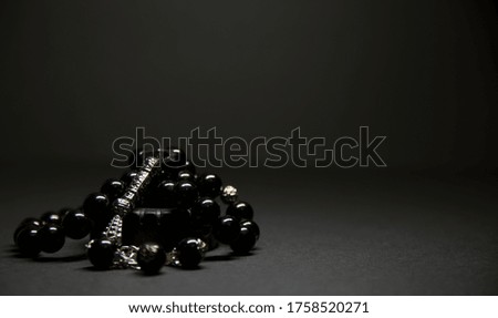 Silver rosary on black background