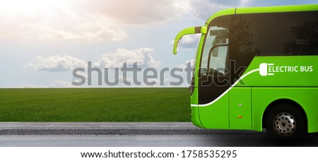 Electric tourist bus on a background of green field Royalty-Free Stock Photo #1758535295