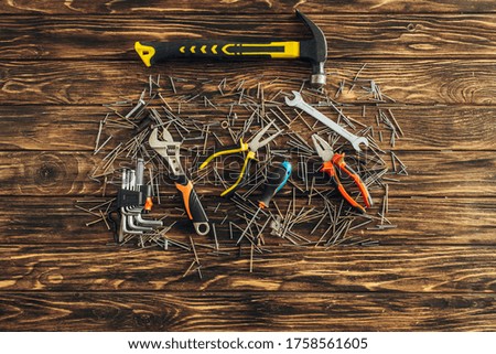 top view of tools and metallic nails on wooden surface, labor day concept