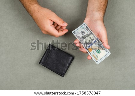 Business and accounting concept with wallet on grey background flat lay. man holding money.