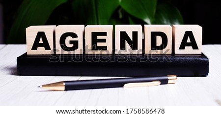 AGENDA word made with building blocks with diary and pen isolated on white background