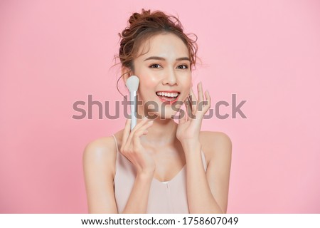 Beautiful girl with cosmetic powder brush for make up. Makeup