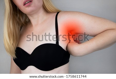 A woman suffers from pain in the armpit. Sweating, unpleasant odor, redness, tooth and inflammation in the armpit. Breast Cancer Prevention Concept Royalty-Free Stock Photo #1758611744