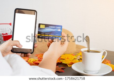 Smartphone with blank screen for mockup eCommerce concept with paying money by use credit card and goods on the desk. Online Technology Payment.