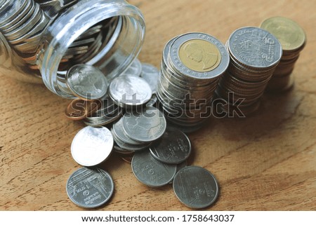 Close-up of many Thai baht coins on a wooden floor selective focus and shallow depth of field