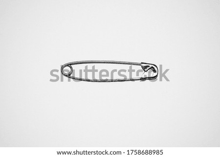 Safety pins on a white studio background 