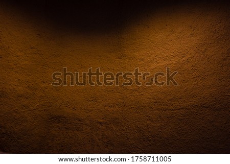 Wall of soil house. texture of clay house structure with orange light. Mud background and dark tone, Blurred Picture
